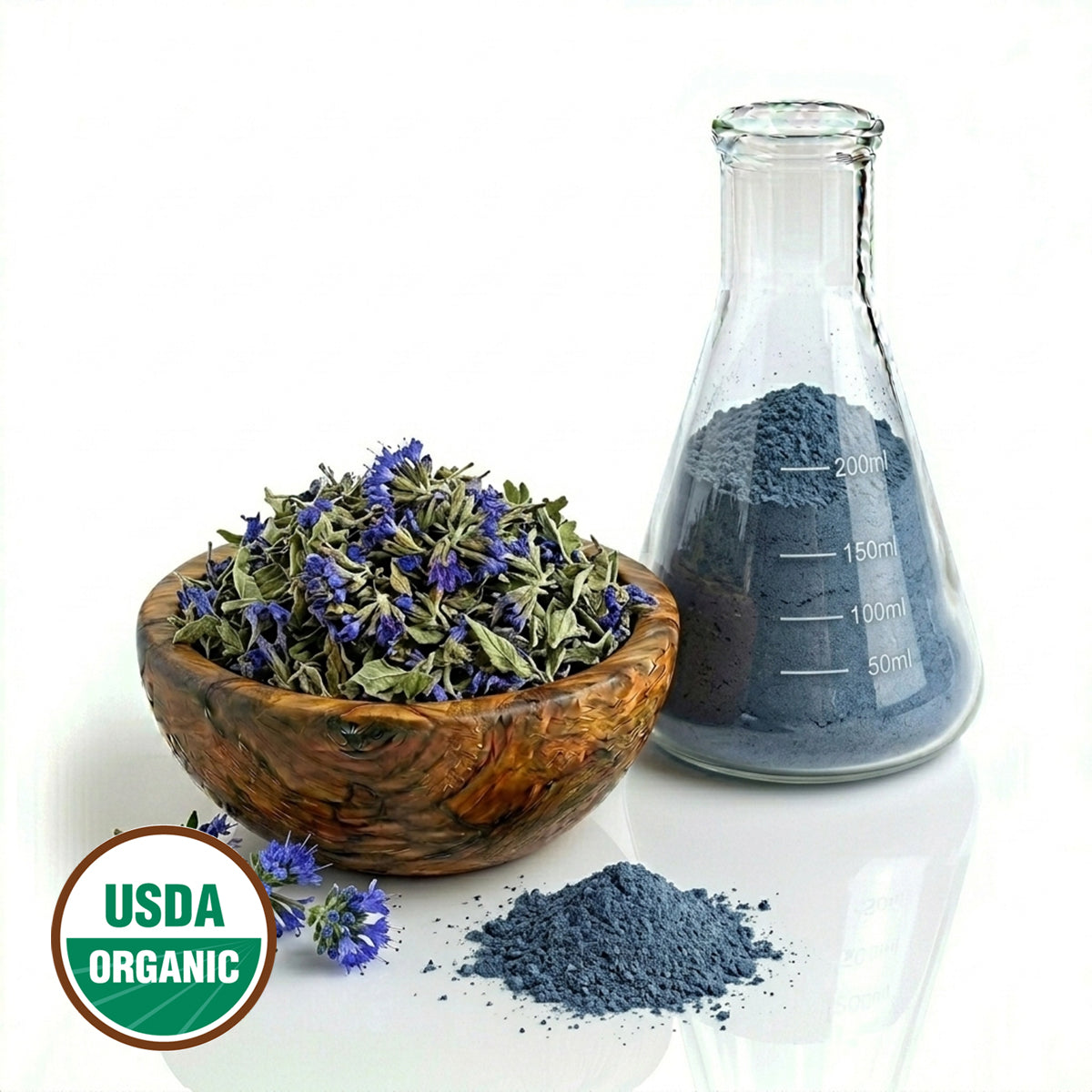 Wooden bowl with dried Blue Beard plant parts, a glass flask with powder, and USDA Organic label on a white background