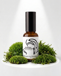 Bottle of Muskoka Wild Harvest product with green moss leaves on a white background