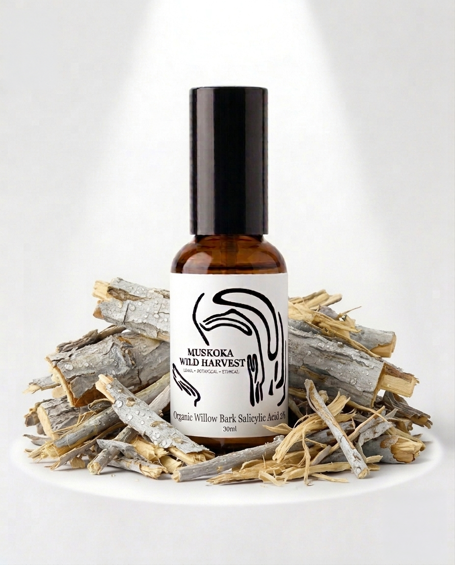 A 30ml amber glass bottle of Muskoka Wild Harvest Organic Willow Bark Salicylic Acid with a black cap and white label, styled on a white surface surrounded by dried bark pieces against a white background.