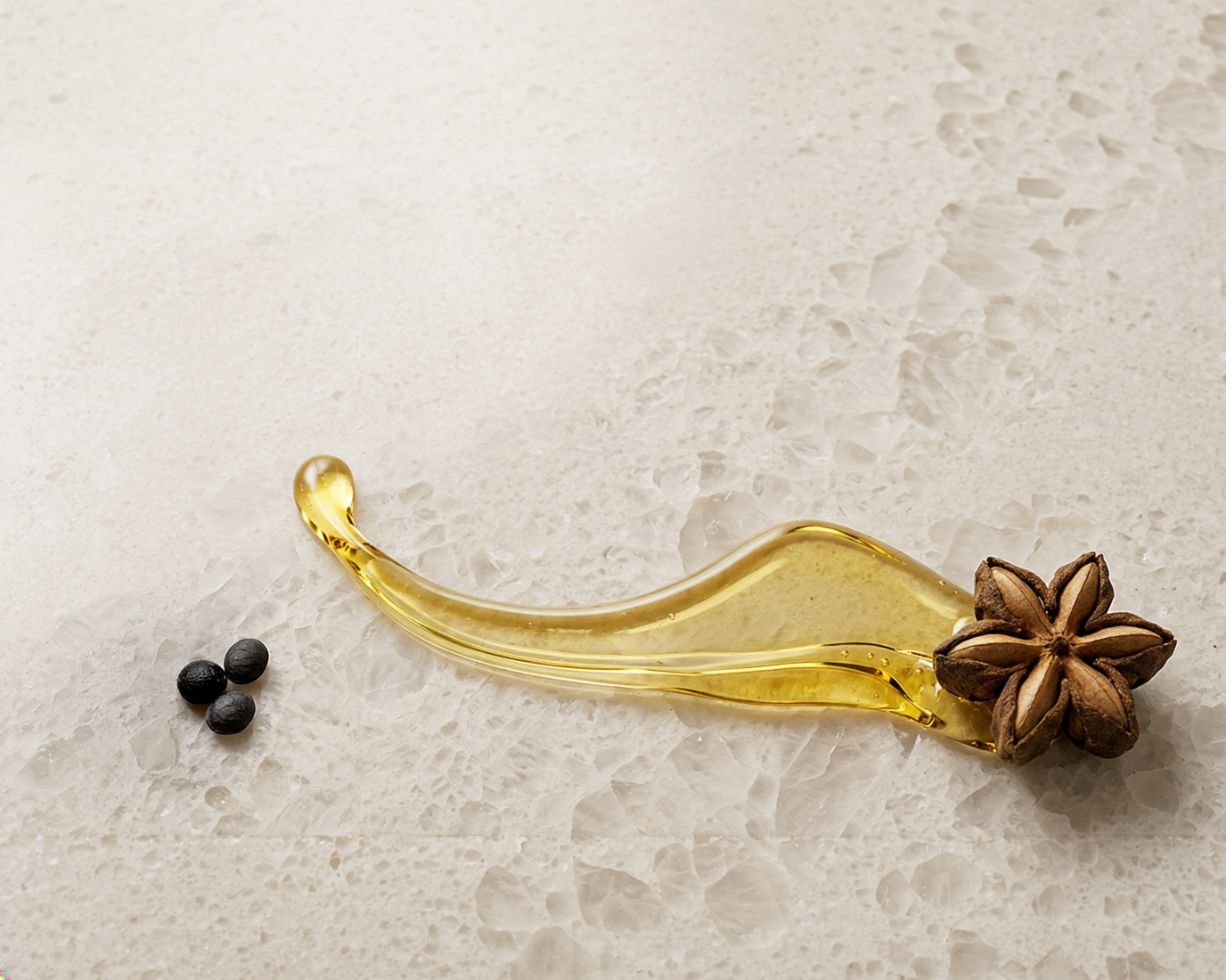 Sacha inchi star seed with an oil splash and three individual seeds on a quartz surface